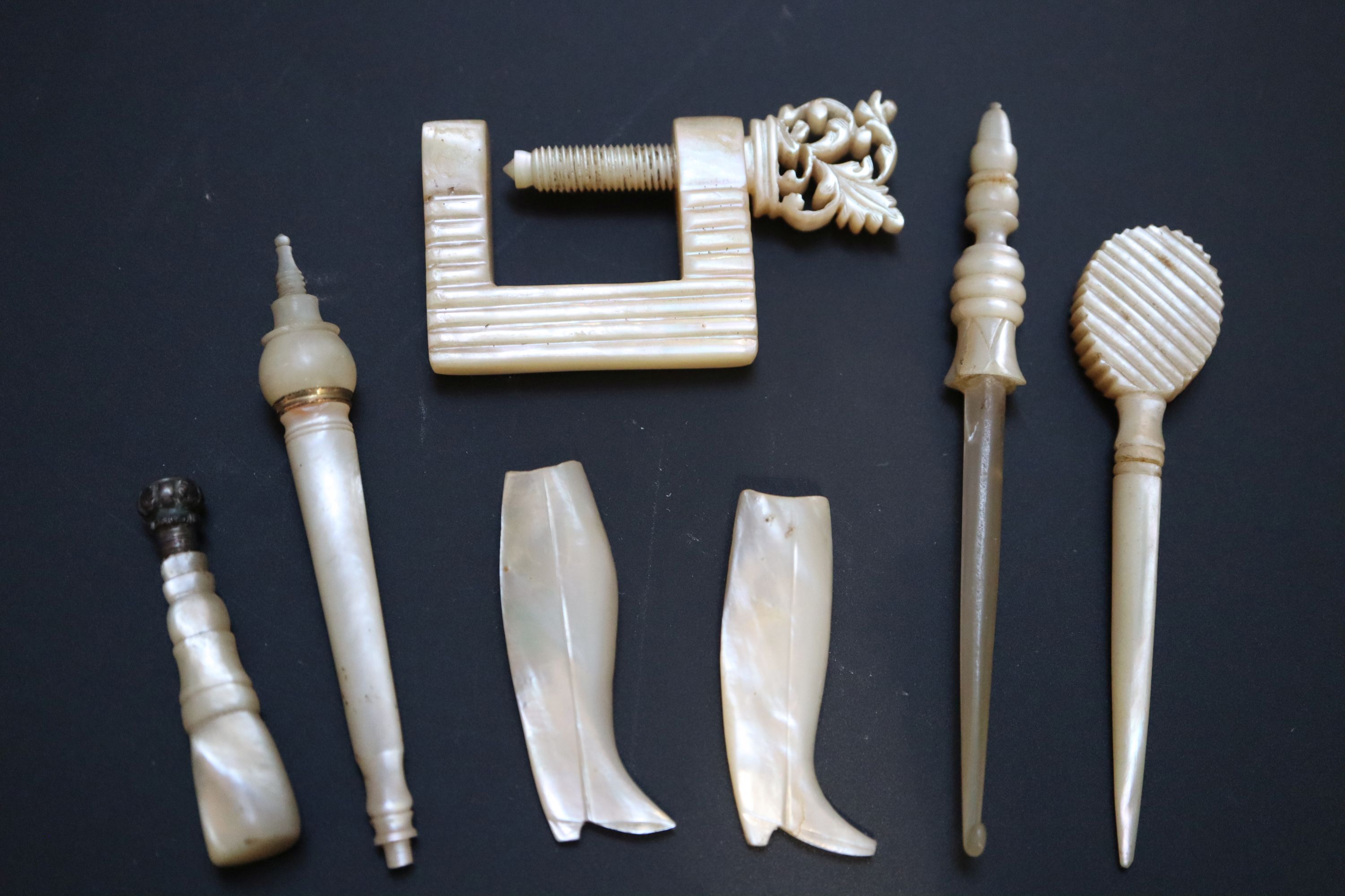 Four 19th century Palais Royale mother of pearl needle cases with gilt mounts, largest 9cm,